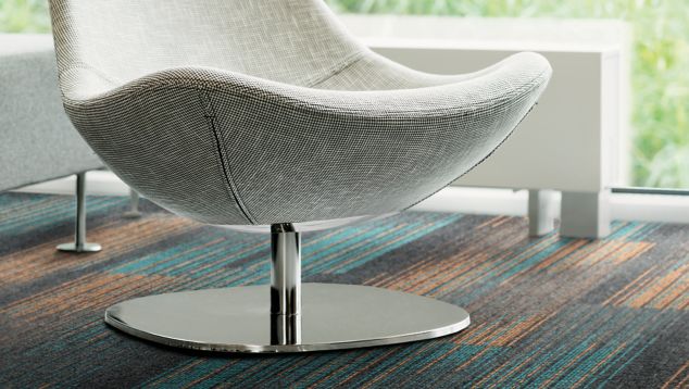 Detail of Interface Ground Waves Verse plank carpet tile with white chair